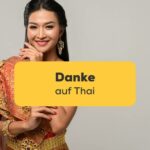 Thailändische Frau in traditioneller Kleidung und sagt Danke auf Thai