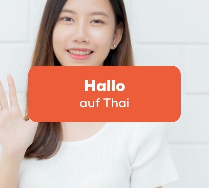 Thailändische Frau winkt um Hallo auf Thai zu sagen