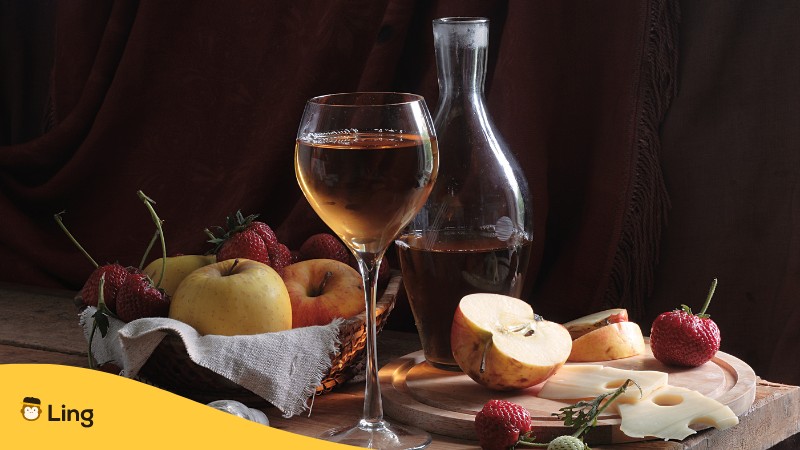 Verschiedene Fruechte mit Glasflasche und Glas mit Fruchtwein