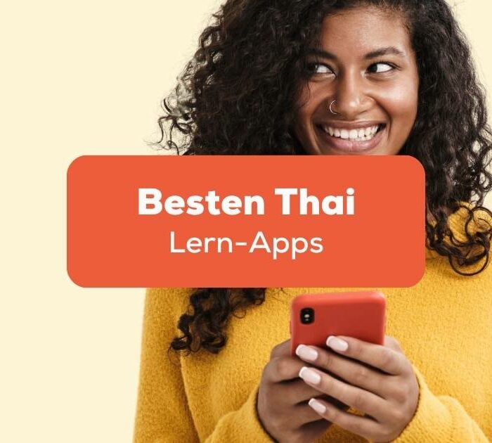 Frau mit Handy an freut sich darüber, die besten Apps um Thai zu lernen gefunden zu haben