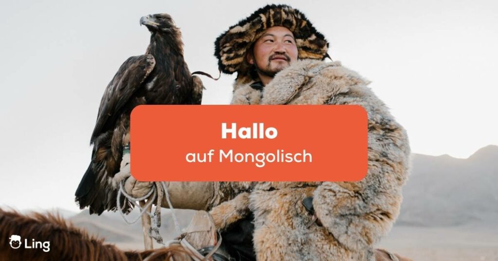 Mongolischer Mann hält einen Raubvogel auf dem Arm und möchte Hallo auf Mongolisch sagen