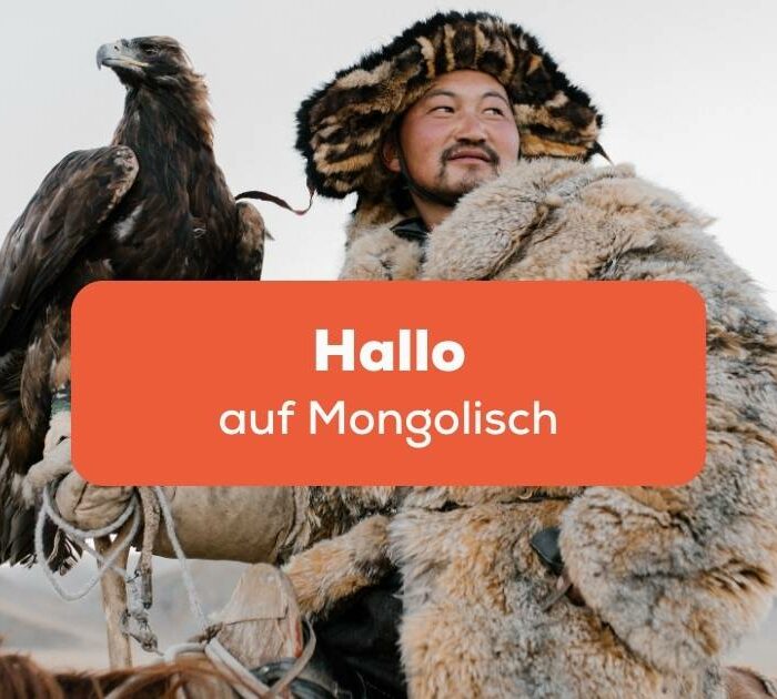 Mongolischer Mann hält einen Raubvogel auf dem Arm und möchte Hallo auf Mongolisch sagen