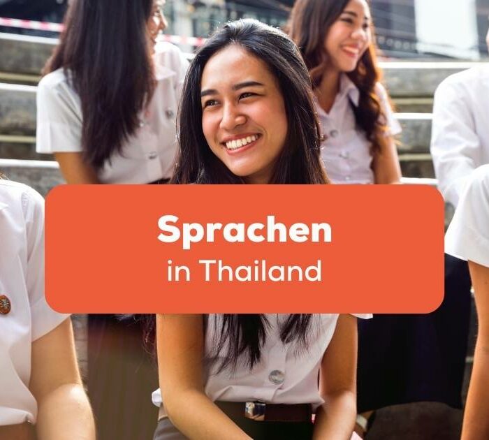 Thailändische Studentinnen sitzen auf einer Treppe und lachen gemeinsam obwohl sie verschieden Sprachen in Thailand sprechen