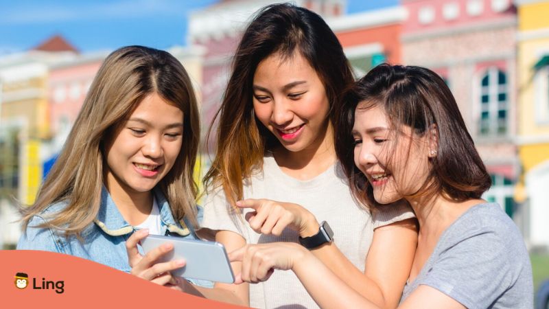 telling the time in Tagalog - A photo of girl friends pointing their fingers to a phone
