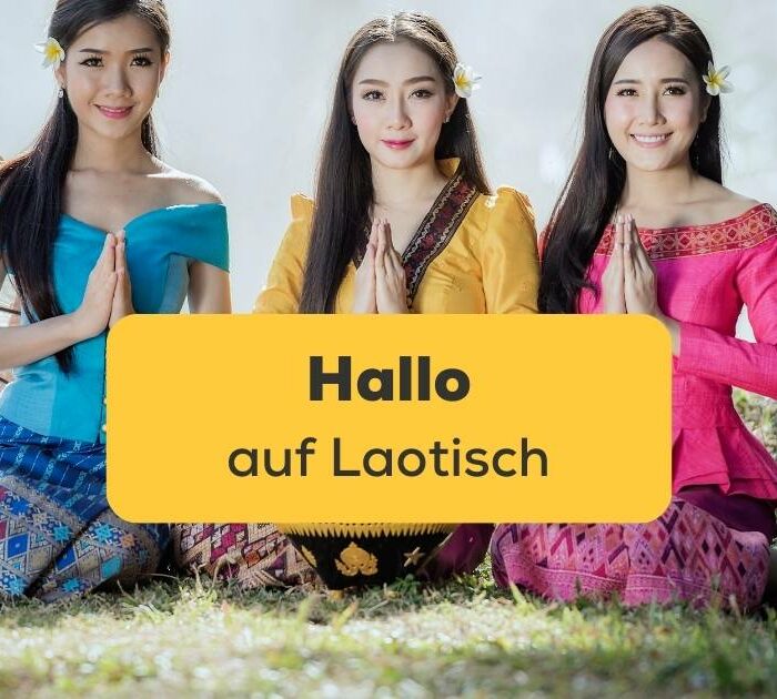 Drei Frauen machen sitzend den Nop um Hallo auf Laotisch zu sagen