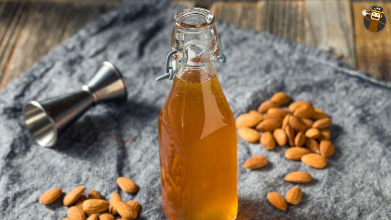 A bottle of orgeat syrup decorated with almonds. 