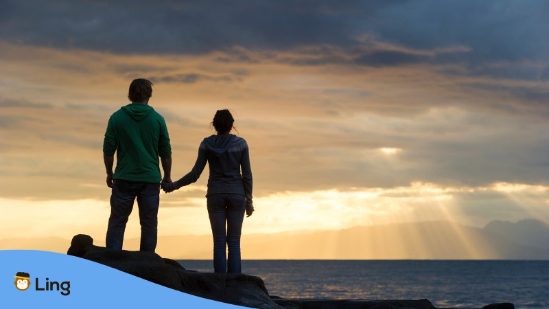 Filipino Couple traveling together and enjoying the sunset by the sea