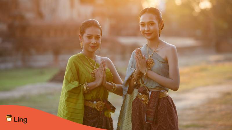 Zwei Thai Frauen in traditioneller Tracht machen den Wai um herzlich Willkommen auf Thai zu sagen