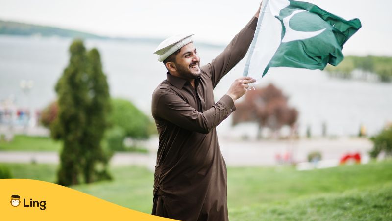 Ein Mann aus Pakistan weht eine pakistanische Flagge