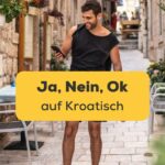 Brünetter Mann läuft durch kroatische Altstadt mit Handy in der Hand und lernt mit der Ling-App wie man Ja Nein Ok auf Kroatisch sagt