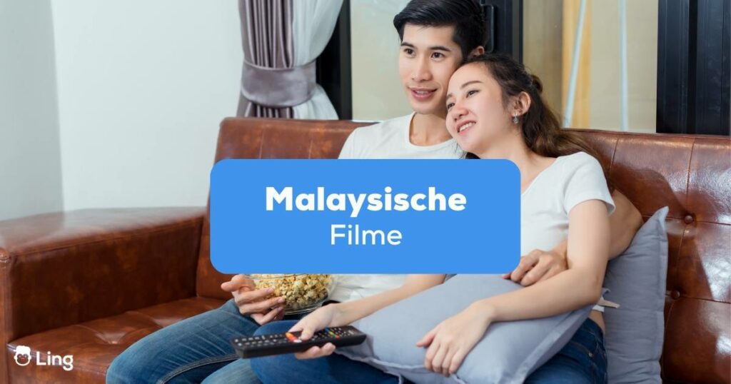 Paar sitzt auf dem Sofa und schaut gemeinsam malaysische Filme an
