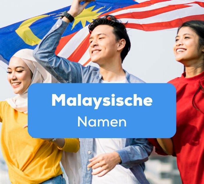 Zwei Frauen und ein Mann halten gemeinsam die Flagge von Malaysia über ihren Köpfen, alle drei tragen malaysische Namen
