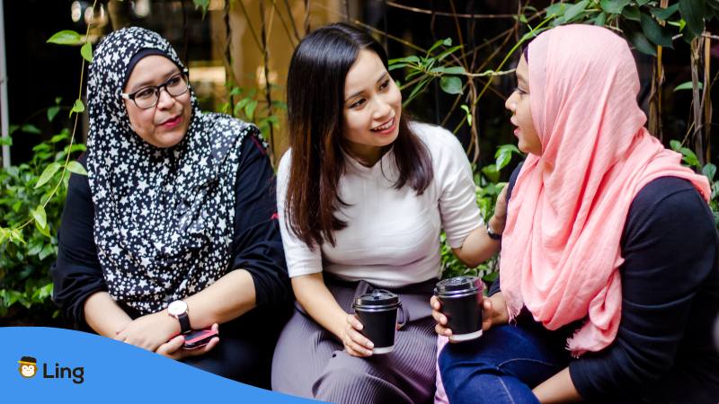 Drei Frauen, zwei davon tragen ein Kopftuch, in Malaysia sitzen zusammen und trinken gemeinsam Kaffee und sprechen über malaysische Namen für Frauen und Mädchen