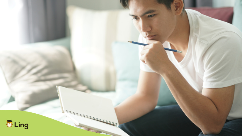 A photo of a deep thinking man studying Tagalog language