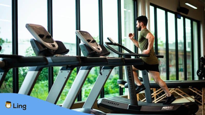 gym vocabulary in Vietnamese - man running on treadmill 