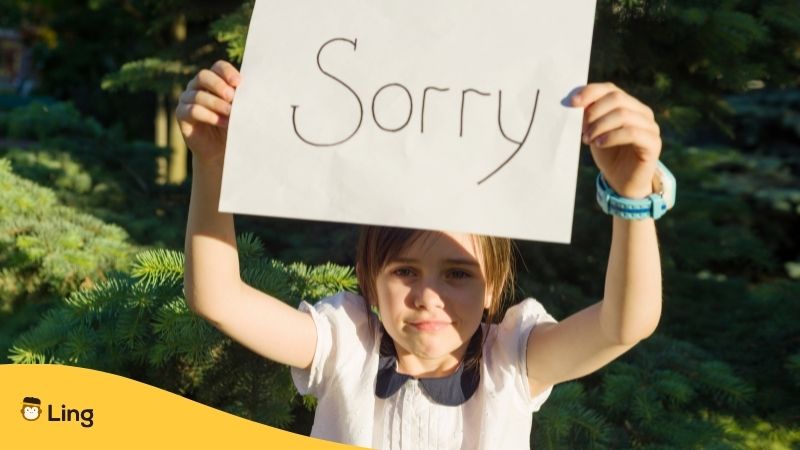 a kid holding a sorry card