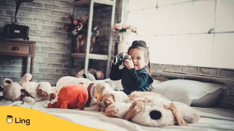 Children's Day In Thai - girl taking a photo on her bed