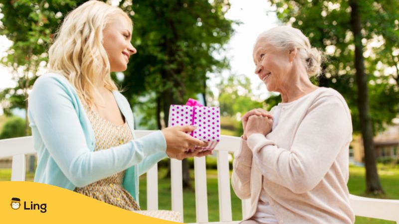 a girl giving a present to an older woman