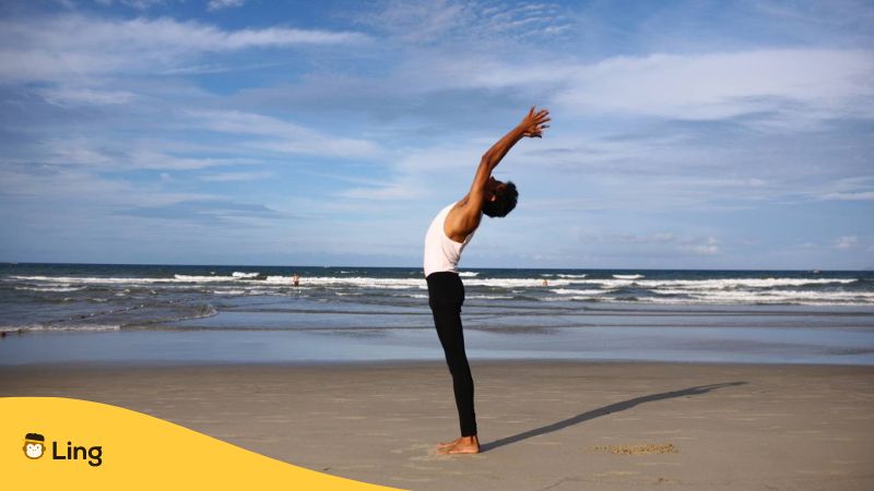 Ein Mann macht Yoga am Strand