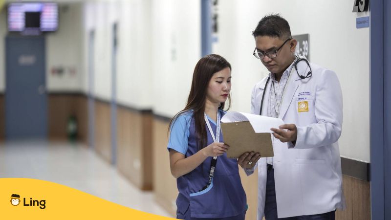 Thailändischer Arzt und Krankenschwester betrachten ein Dokument- Gesundheit auf Thai