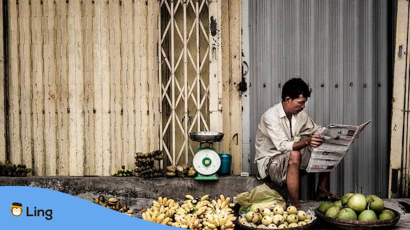 Ordering food in Vietnamese-man-reading-newspaper-at-fruit-shop