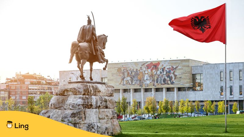 Statue und Albanienflagge auf dem Skandebeg Platz in der albanischen Hauptstadt Tirana