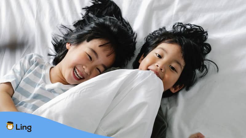 Thai phrases for kids - children laughing on bed