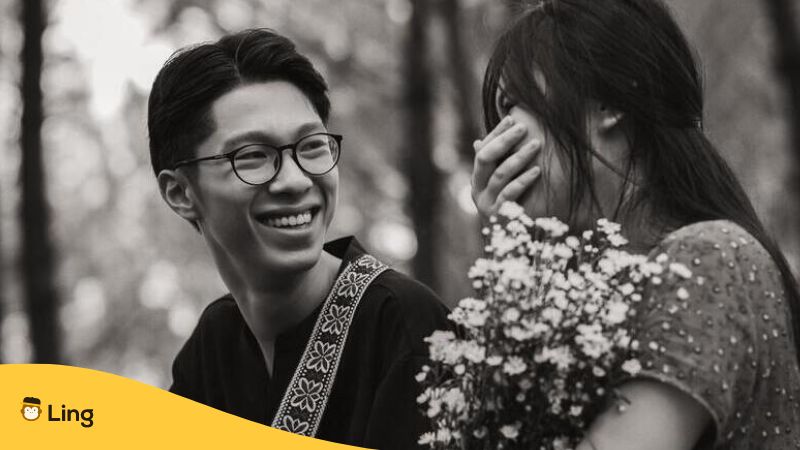 Thai Mann bringt Frau mit Blumen zum Lachen
