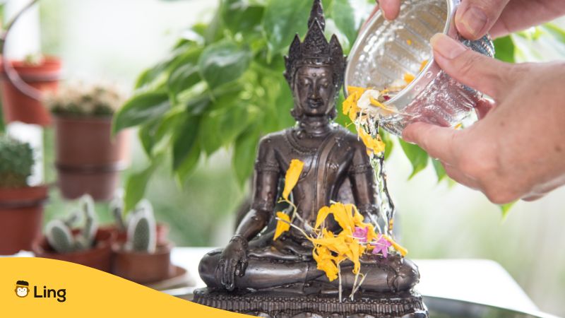 Buddhastatue wird zum buddhistischen Neujahr Songkran mit Wasser übergossen