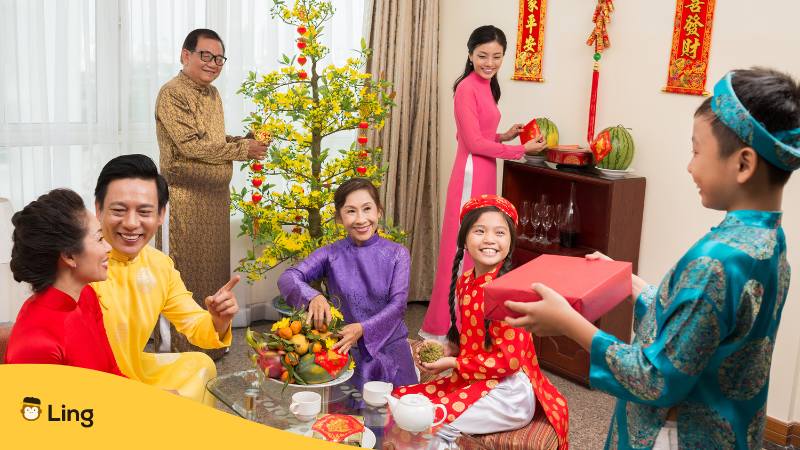 Vietnamesische Familie feiert zusammen das vietnamesische Neujahr Tet-Fest und verteilt Geschenke