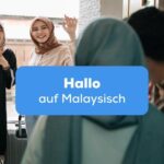 Zwei Frauen im Kopftuch stehen an der Türe und winken um Hallo auf Malaysisch zu sagen