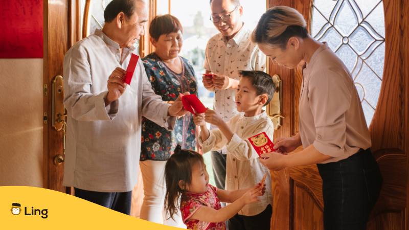 Familien in Vietnam steht an der Haustüre und verteilt rote Umschläge als Tradition zum vietnamesischen Neujahr