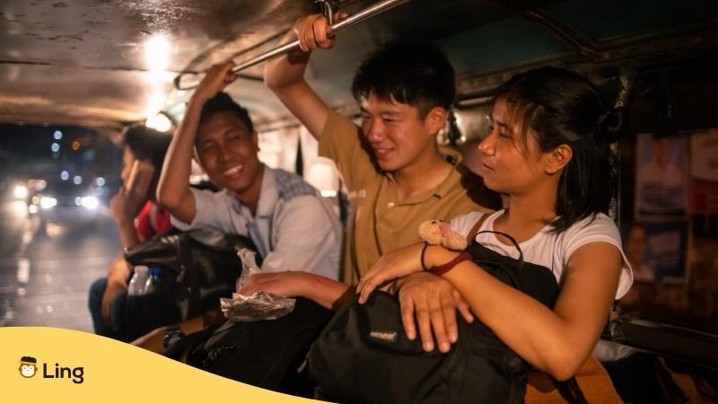 A foreigner talking with Filipinos inside a jeepney.