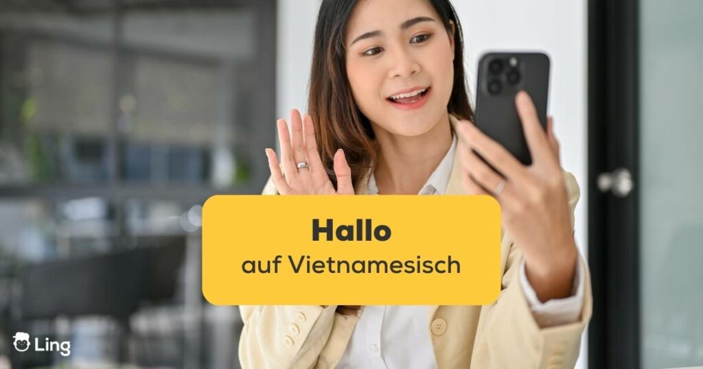 Vietnamesische Frau winkt in die Handykamera um Hallo auf Vietnamesisch zu sagen