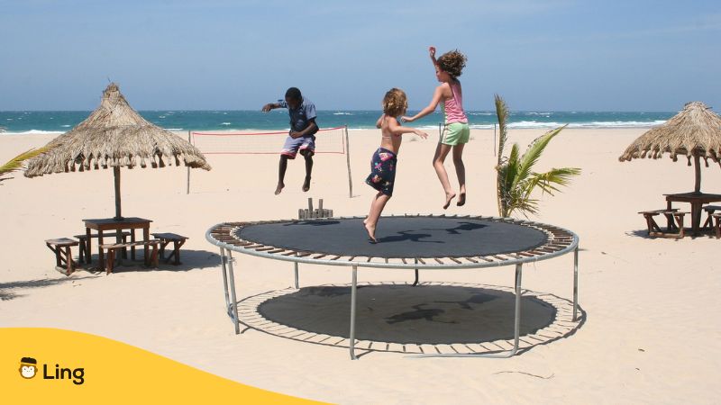 Kinder auf dem Trampolin am Strand in Thailand