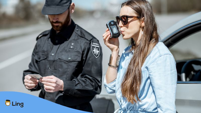 Police officer apprehending a drunk driving lady.