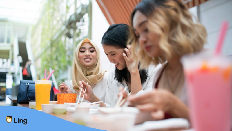 Malaysian ladies eating using their chopsticks.