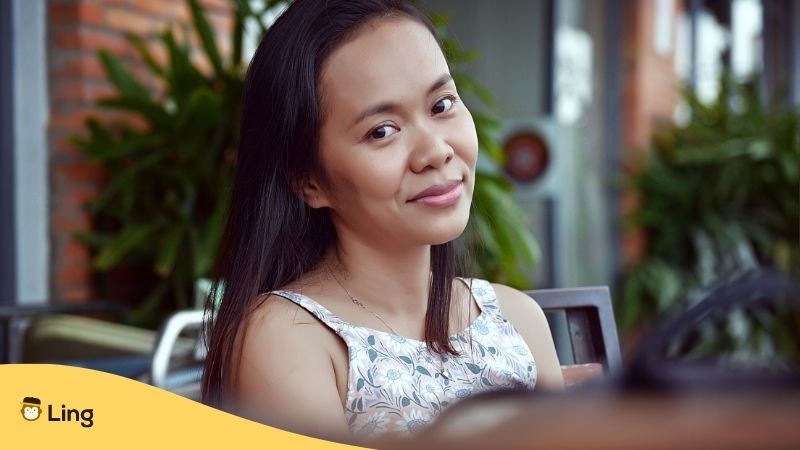 History Of Khmer Language. Cambodian lady smiling sitting outside a cafe in Phnom Penh.