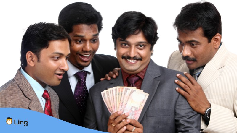 An Indian with friends showing his money.