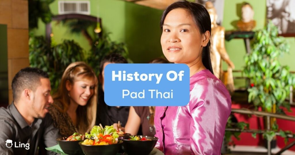 A Thai lady waitress who knows the history of Pad Thai serving tourists Thai foods.