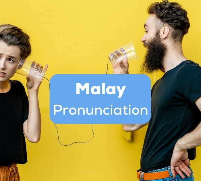 Tourist couple learning Malay pronunciation together.