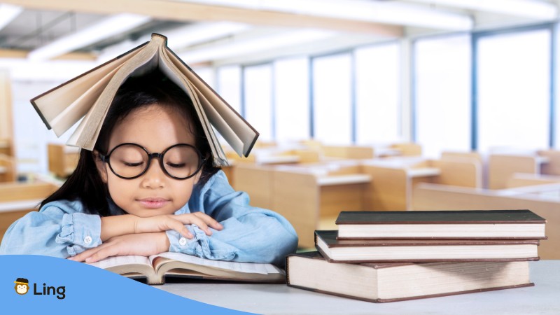 A girl reading Thai textbooks as one of the best ways to learn Thai.