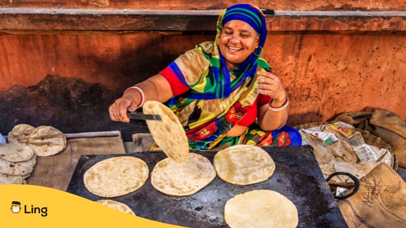 Eine Frau kocht in Indien Essen auf der Straße