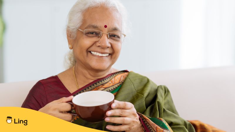 Eine tamilische Frau trinkt aus einer Tasse