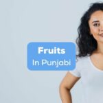A curly beautiful lady beside fruits in Punjabi text.