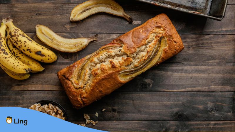 Bananas and a banana bread on a wooden table.