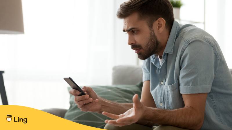 Mann Sitzt Auf Einem Sofa Und Schaut Böse Auf Sein Handy Und Sagt Vietnamesische Fluchwörter