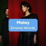 A stage actor and actress divided by red curtain behind the Malay drama words text.