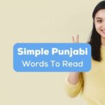 A pretty girl in an OK hand sign beside simple Punjabi words to read text.