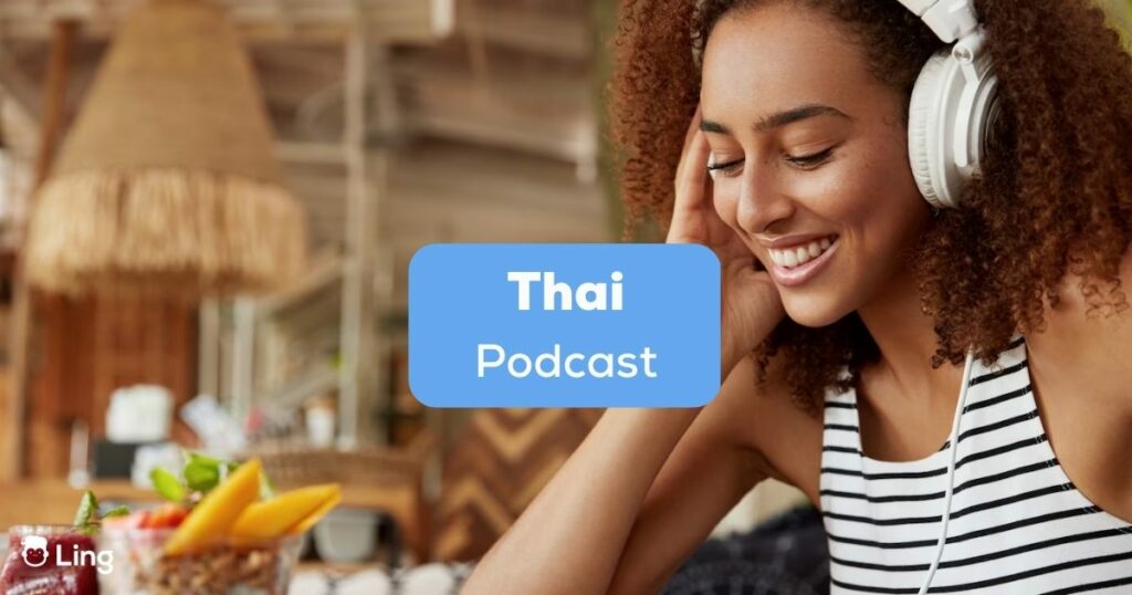 A happy young African-American female in headphones listening to a Thai podcast in a cozy cafeteria.